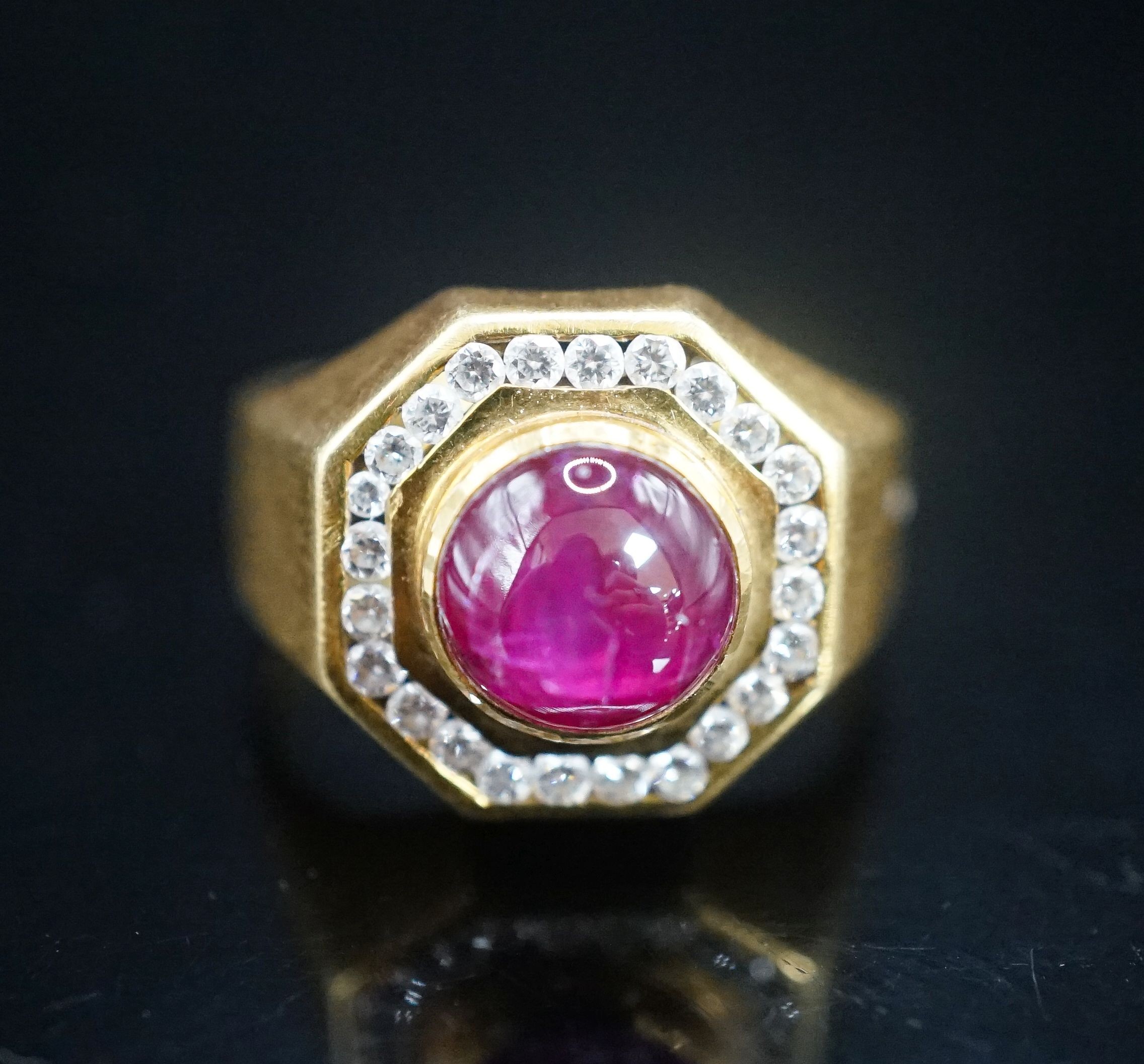 A modern continental yellow metal, cabochon ruby and diamond cluster set octagonal dress ring, size Q, gross weight 9.9 grams.